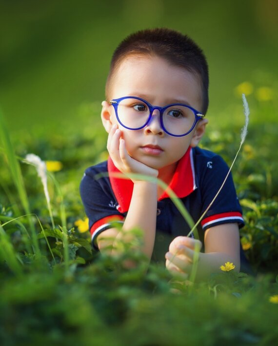 Boy kid in the field wearing glasses